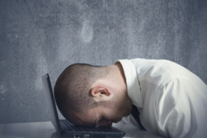Male hitting head on laptop keyboard